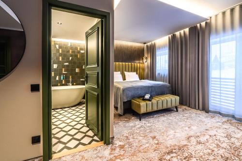 een slaapkamer met een bed, een bad en een spiegel bij Ugandi Hotel in Otepää