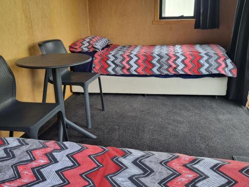 a room with a bed and a table and chairs at Murchison Motorhome Park in Murchison