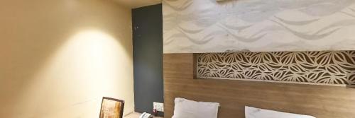 een hotelkamer met een groot schilderij aan de muur bij Hotel Sagar Executive BEED in Bīr