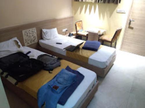 een hotelkamer met 2 bedden en een tafel bij Hotel Sagar Executive BEED in Bīr