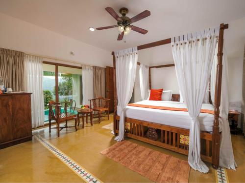una camera con letto e ventilatore a soffitto di Tapovana The Fern Heritage Resort, Sakleshpur a Sakleshpur