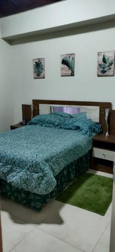 a bedroom with a bed with a blue comforter and a desk at Guango Grove Cozy Corner in Montego Bay