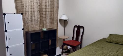 1 dormitorio con 1 cama, vestidor y silla en Guango Grove Cozy Corner, en Montego Bay