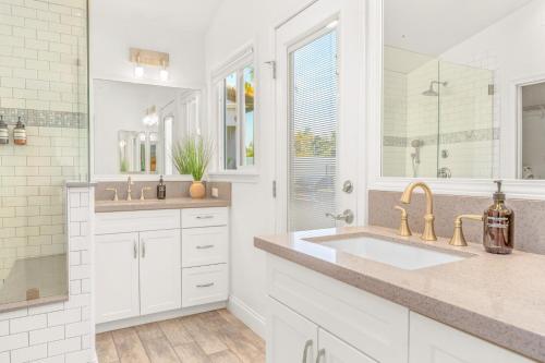 een witte badkamer met 2 wastafels en een spiegel bij Villa Descanso in Oceanside