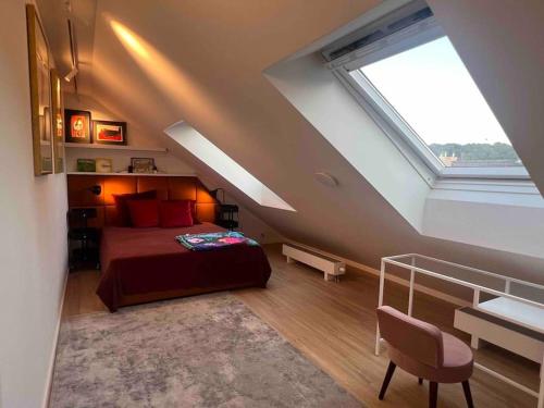 a attic bedroom with a bed and a window at KAUNAS ATTIC, Apartment in the heart of Kaunas in Kaunas