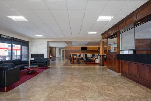 an office lobby with couches and a table at Holiday Inn Des Moines-Airport Conf Center by IHG in Des Moines