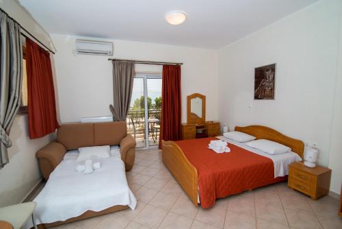 a hotel room with two beds and a couch at Rooms Nancy in Agios Andreas