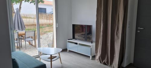 un soggiorno con TV su un comò di Maison vendéene bord de mer - env 1 km plage- a Saint-Vincent-sur-Jard
