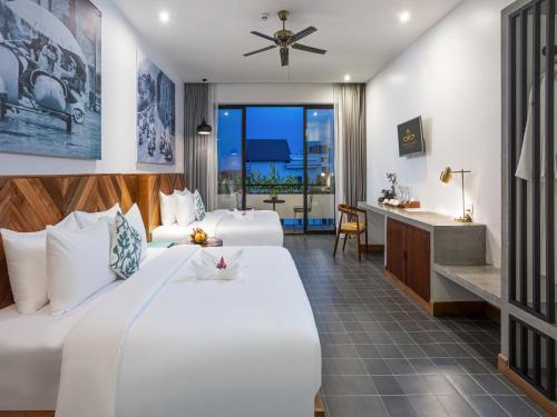una camera d'albergo con 2 letti e una scrivania di Grand Yard La Residence a Siem Reap