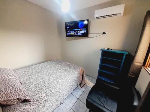 um quarto com uma cama e uma TV na parede em 2 quartos com ar - Apto em condomínio em Campo Grande