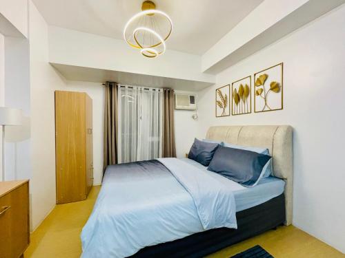ein Schlafzimmer mit einem Bett mit blauen Kissen in der Unterkunft Studio Unit with Balcony at Centrio Towers beside Ayala Mall Downtown CDO in Cagayan de Oro