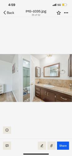 a bathroom with a sink and a mirror at Del Mar pool Home in Fresno