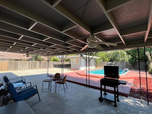 a screened in porch with a ceiling fan and a piano at Del Mar pool Home in Fresno