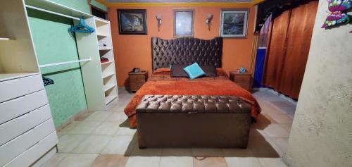 een slaapkamer met een bed met een rode sprei bij House of Irma in Santa María Chimalhuacán