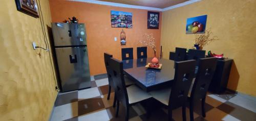 een keuken met een tafel en stoelen en een koelkast bij House of Irma in Santa María Chimalhuacán