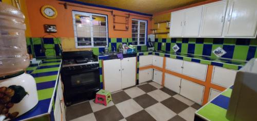 eine farbenfrohe Küche mit einem karierten Boden in der Unterkunft House of Irma in Santa María Chimalhuacán