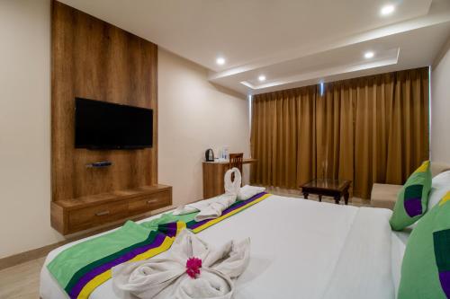 a bedroom with a large bed with a flat screen tv at Treebo Sonal Palace, Near Umaid Bhawan Palace in Jodhpur