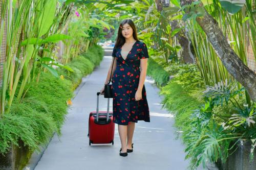 a woman with a red suitcase pulling a red suitcase at Rama Residence Petitenget in Seminyak