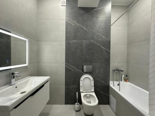 ein Badezimmer mit einem WC, einem Waschbecken und einer Badewanne in der Unterkunft Comfortable Apartment located in downtown Bishkek in Bischkek