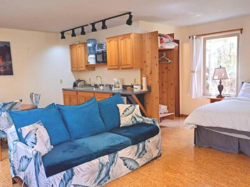 uma sala de estar com um sofá azul e uma cozinha em Halema'uma'u- Hale Kumu La'au em Volcano
