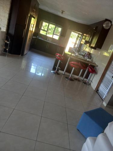 an empty living room with red chairs and a counter at Queens and king2 in Pinetown