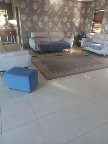 a living room with couches and a blue box on the floor at Queens and king2 in Pinetown