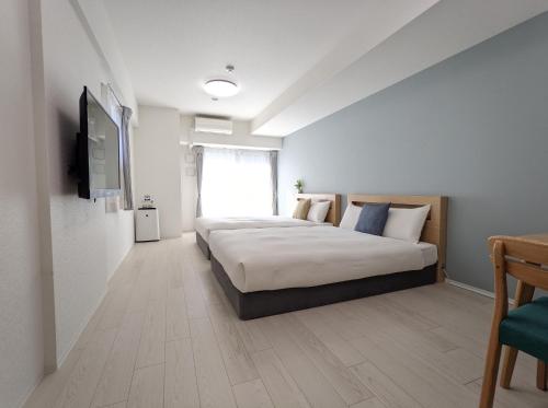 1 dormitorio con 1 cama y TV de pantalla plana en ESLEAD HOTEL Namba South Ⅲ en Osaka