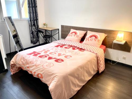 a bedroom with a large bed with a red and white blanket at La Sérénade Numéro 2 in Montreuil