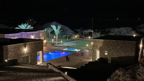 a night view of a courtyard with a swimming pool at إستراحة البيت الحجري in Fulūj Sayghah
