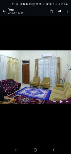 a living room with two chairs and a couch at Homestay Rose Guest House 2.0 in Gambang