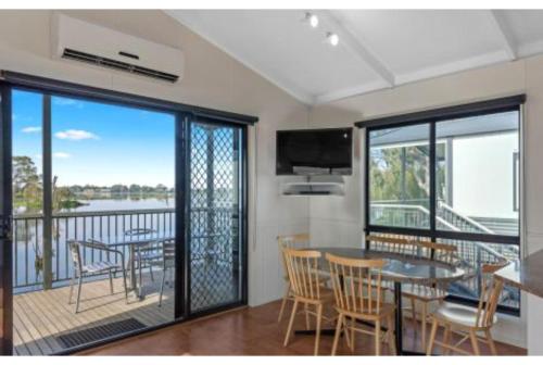 a dining room with a balcony with a table and chairs at Discovery Parks - Nagambie Lakes in Nagambie
