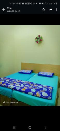 2 camas en una habitación con sábanas y almohadas azules en Homestay Rose Guest House 2.0, en Gambang