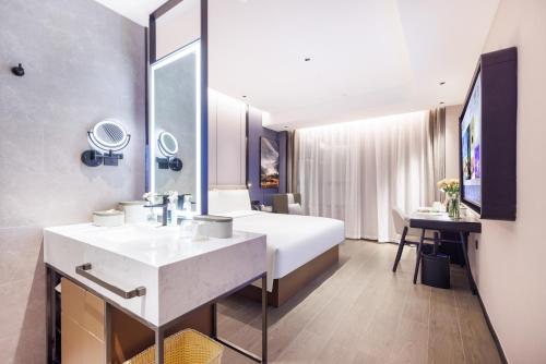 Cette chambre comprend un lit et un lavabo. dans l'établissement Atour Hotel Shenzhen Huaqiangbei Commercial Center, à Shenzhen