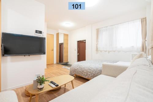 uma sala de estar com um sofá, uma cama e uma televisão em Shinjuku area/Family-apartment/4 min to Subway em Tóquio