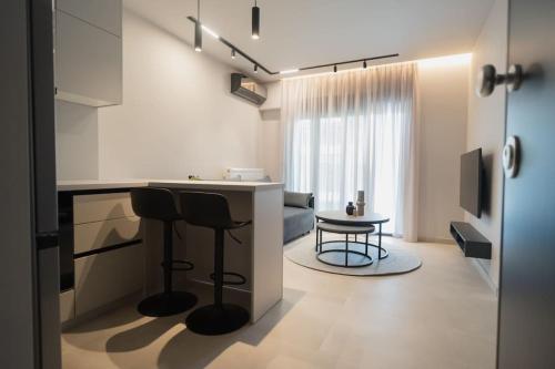 cocina y sala de estar con barra y sillas en ID Residences 102 en Volos