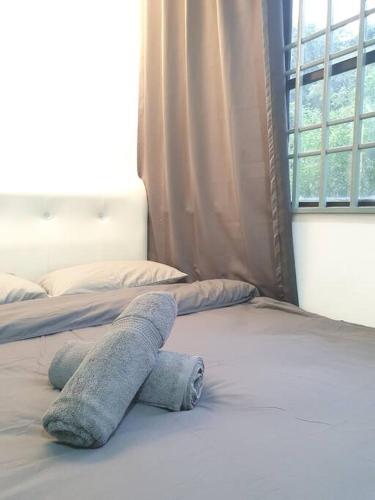 a stuffed animal is laying on a bed at 3 Storey Bangalow near Spice Arena & Queensbay Mall in Bayan Lepas