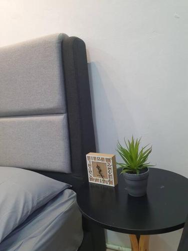 a table with a clock on it next to a bed at 3 Storey Bangalow near Spice Arena & Queensbay Mall in Bayan Lepas