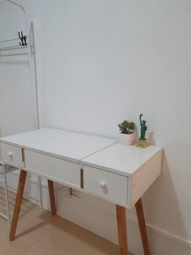 a white desk with two potted plants on top of it at 3 Storey Bangalow near Spice Arena & Queensbay Mall in Bayan Lepas