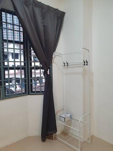 a black curtain in a room with a window at 3 Storey Bangalow near Spice Arena & Queensbay Mall in Bayan Lepas