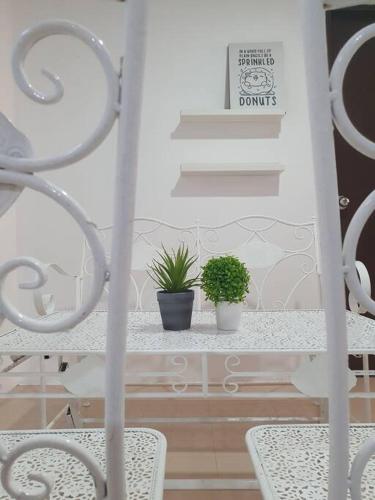 two plants on a table with two chairs and stairs at 3 Storey Bangalow near Spice Arena & Queensbay Mall in Bayan Lepas