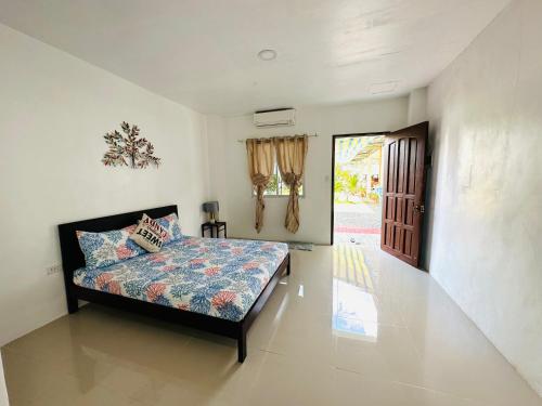 Tagum的住宿－VMJ Inland Resort，一间卧室设有一张床,一扇门通往庭院