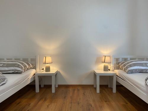 two beds in a room with two lamps on tables at Haus 77 in Hollabrunn