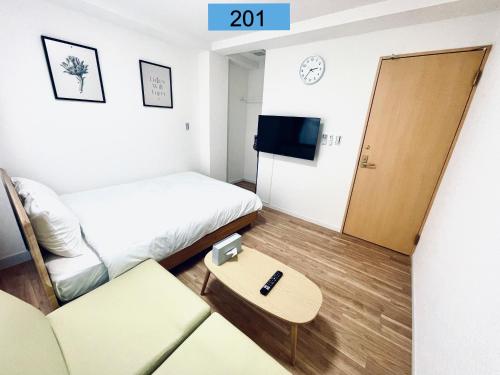 a small room with a bed and a couch and a table at Shinjuku area/Family-apartment/4 min to Subway in Tokyo