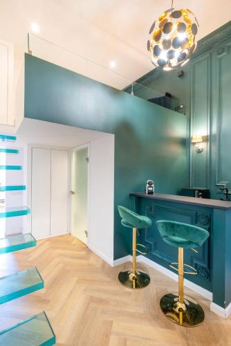 a room with blue walls and a bar with stools at TOP Luxury Suites in Budapest