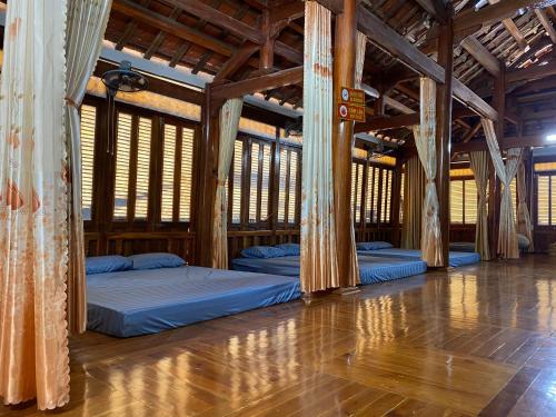 two beds in a room with wooden ceilings at Homestay-Nhà Sàn Ngán Chải in Ha Giang