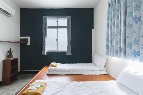a bedroom with a white bed and a window at Tropical Low Boundary B&B in Donghe