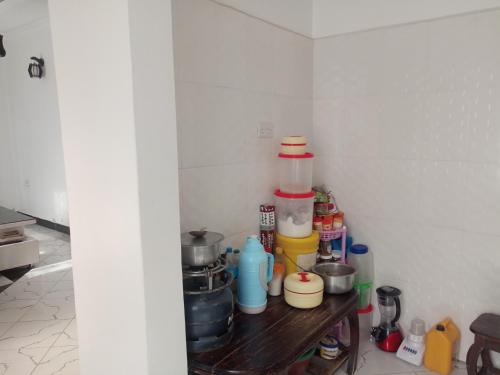 a corner of a kitchen with a shelf with food at Millance volunteer hosting in Arusha