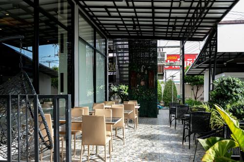 a restaurant with tables and chairs on a patio at Grand Ratchapruek Hotel in Ban Bang Phlap
