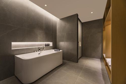La salle de bains est pourvue d'une baignoire et d'un lavabo. dans l'établissement Atour Hotel Jinan West Railway Station, à Jinan