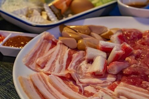 a plate of ham and vegetables on a table at Sangthong Resort at Chiang Klang in Chiang Klang